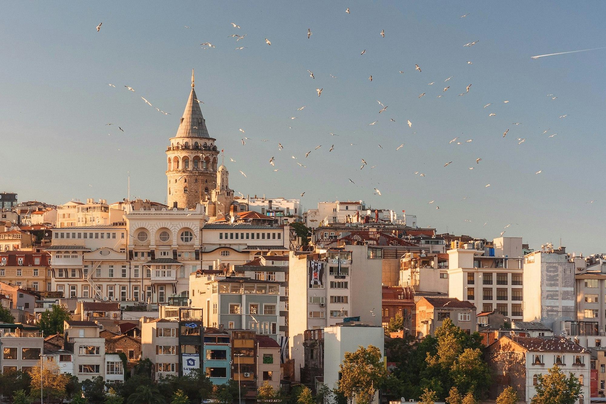 Gün batımında İzmir'de kubbe ve minarelerle çevrili şehir silueti